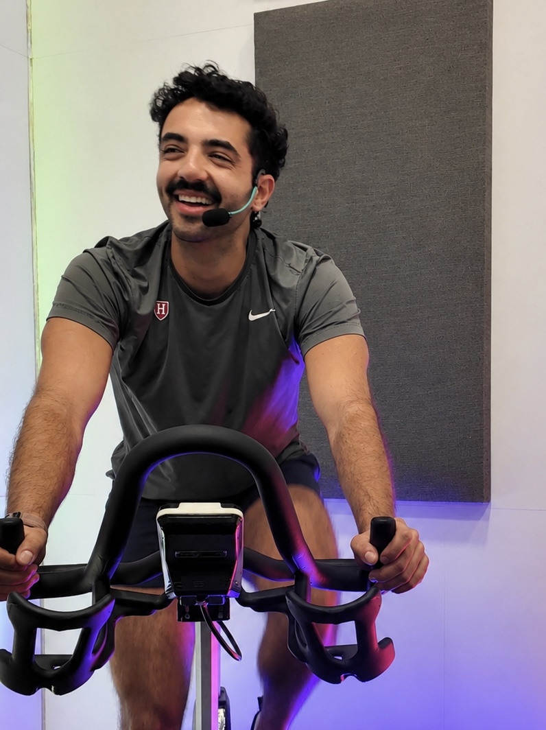 Matine Khalighi teaching an indoor cycling class, headset mic on